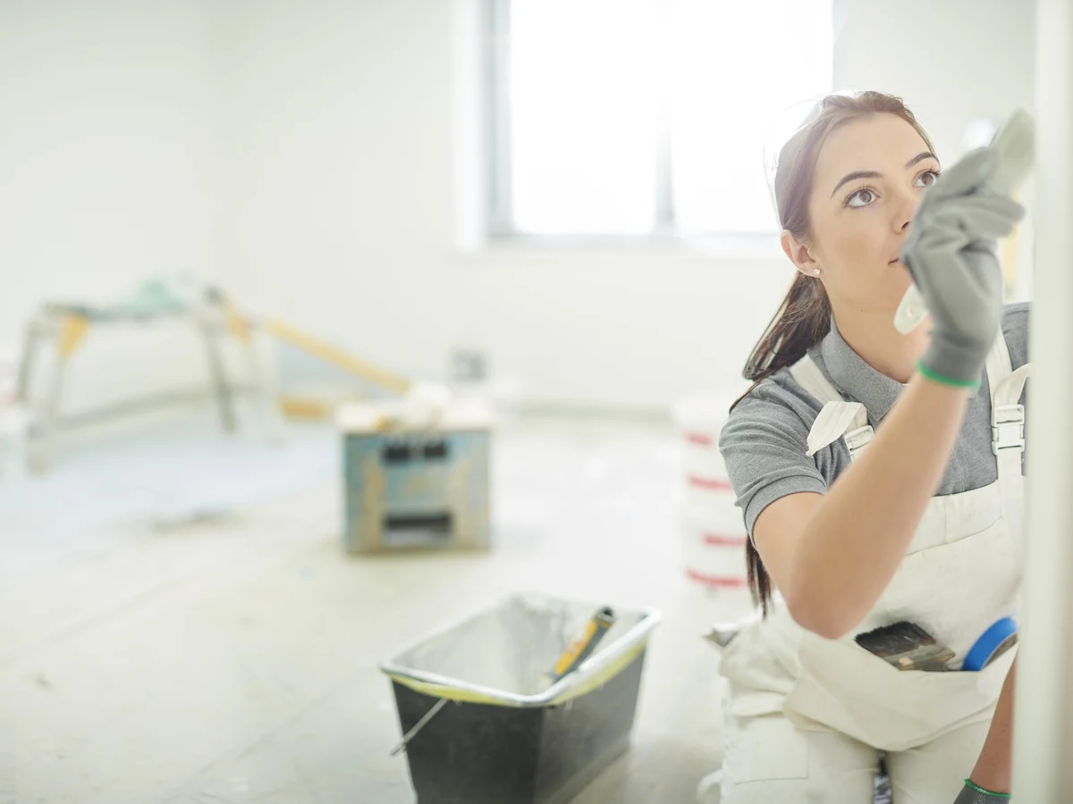 Female painter smoothing a wall finish during home renovation in Harrogate